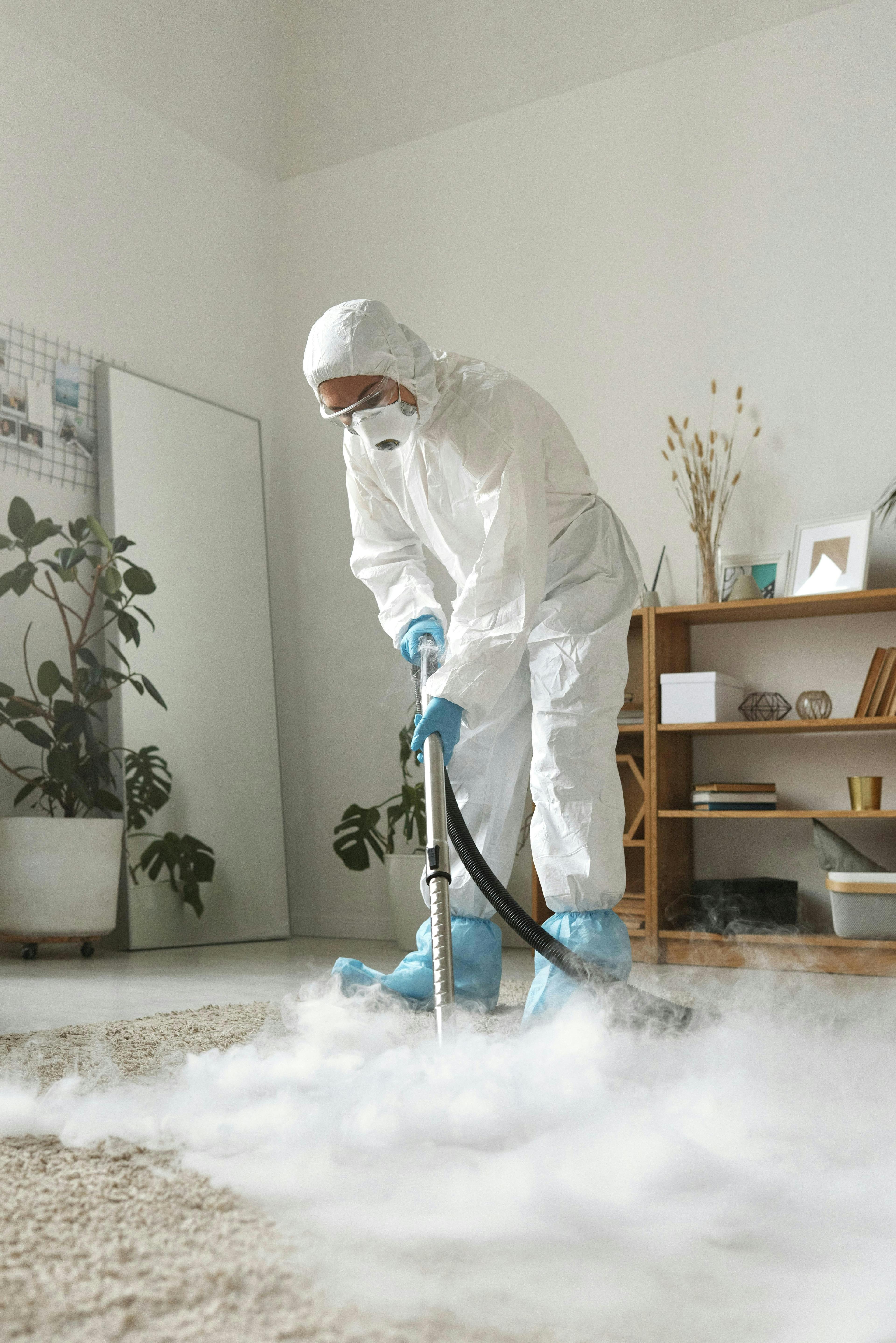 Technician in protective suit steam-cleaning flooring