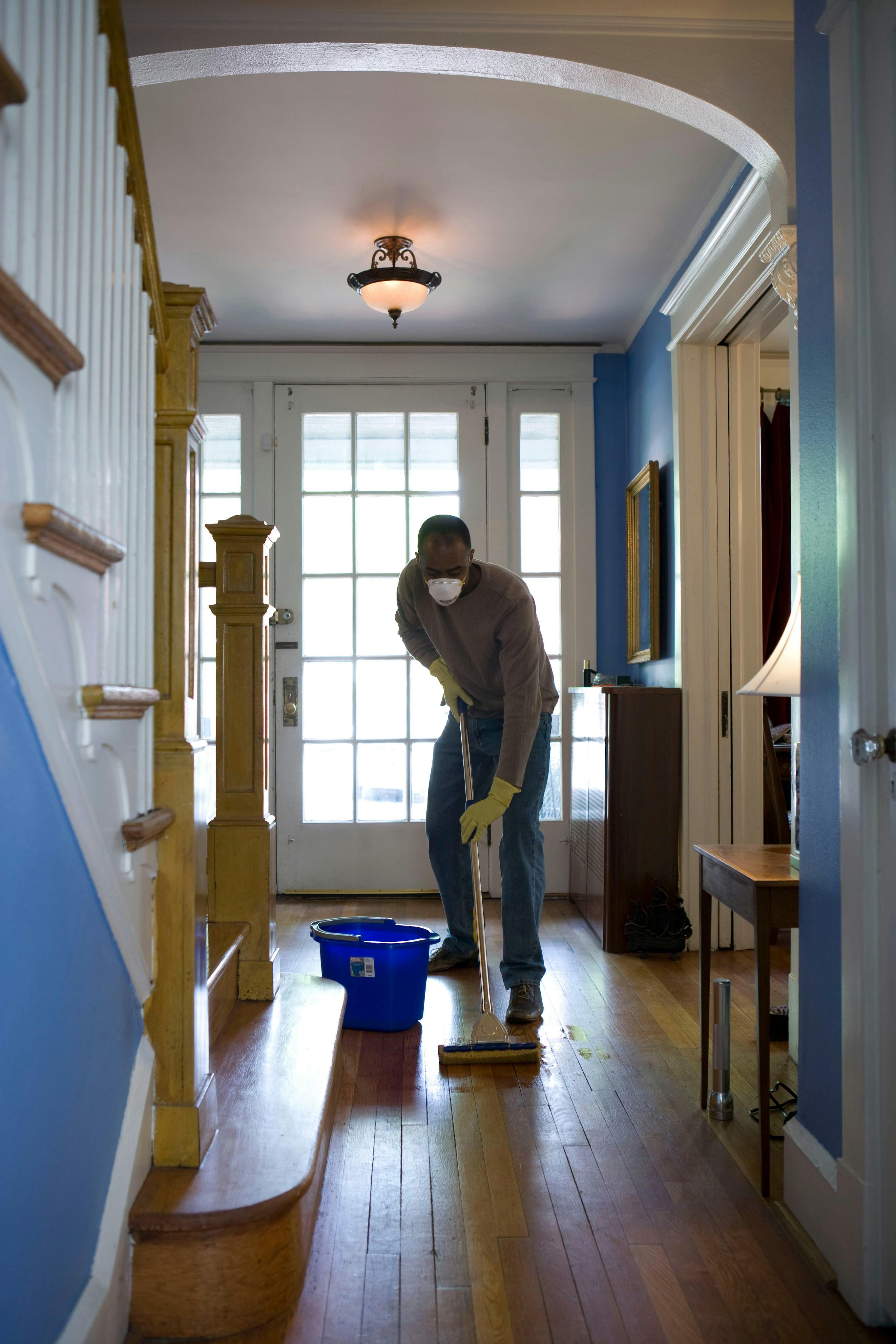 Professional cleaner mopping a bright entryway
